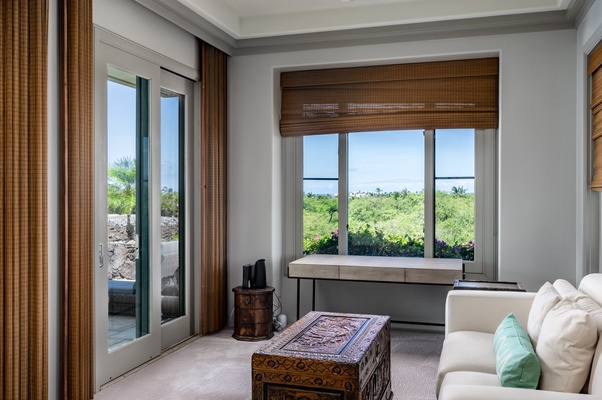 Cozy seating nook with a writing desk and large windows, offering beautiful views.