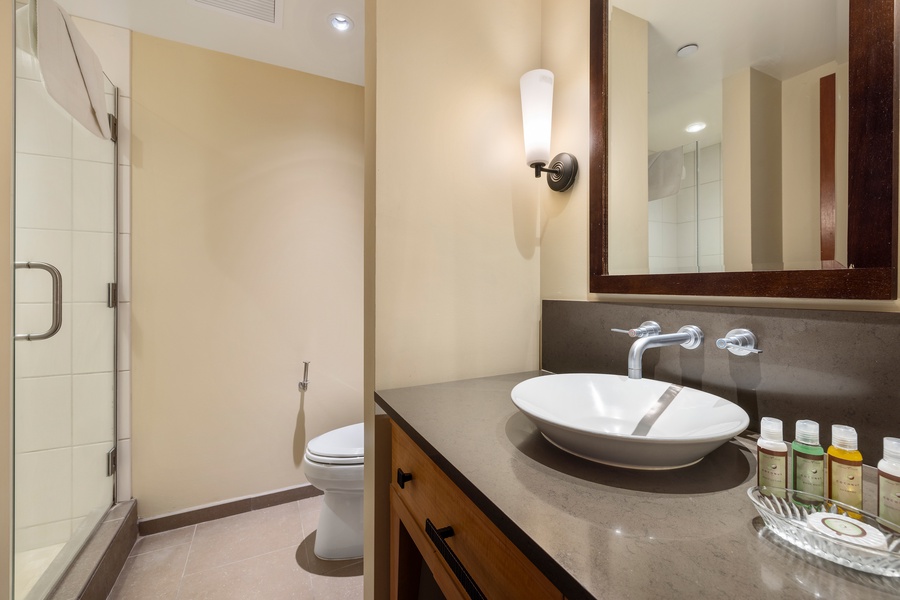 Step into your elegant bathroom featuring a sleek vessel sink, spacious walk-in shower, and modern amenities to refresh after your day.