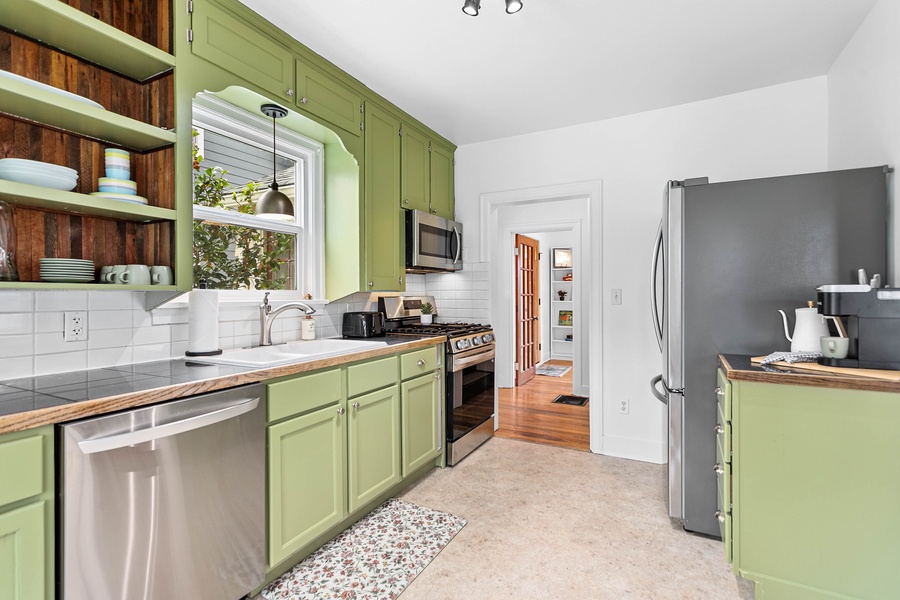 Sleek and functional, the fully equipped kitchen includes modern appliances, ample counter space, and open shelving.
