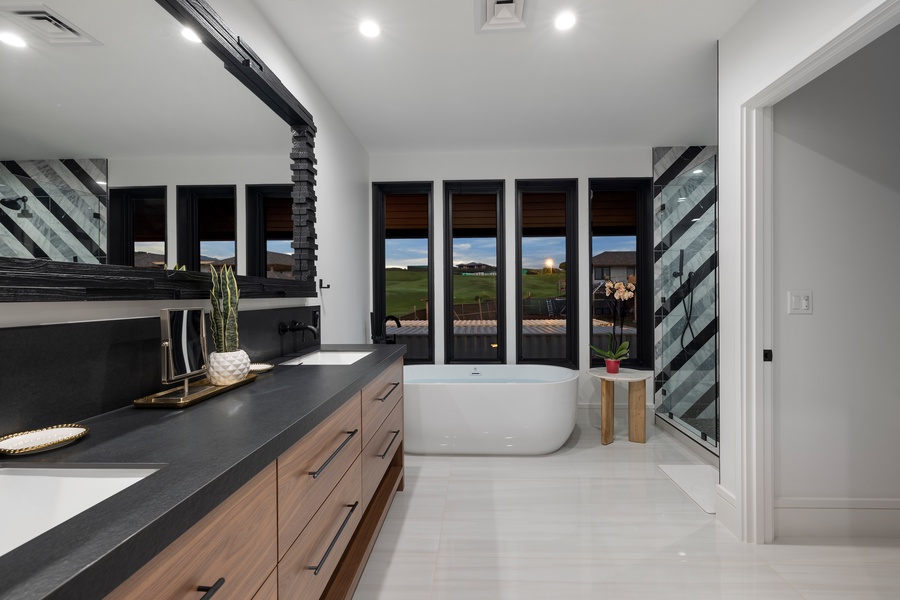Enjoy the sleek modern bathroom featuring freestanding tub and sunset views, perfect for unwinding.