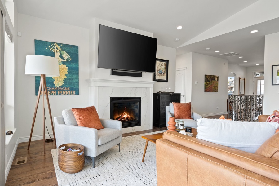 Engaging conversations and cozy moments unfold by the fireplace in the inviting living area