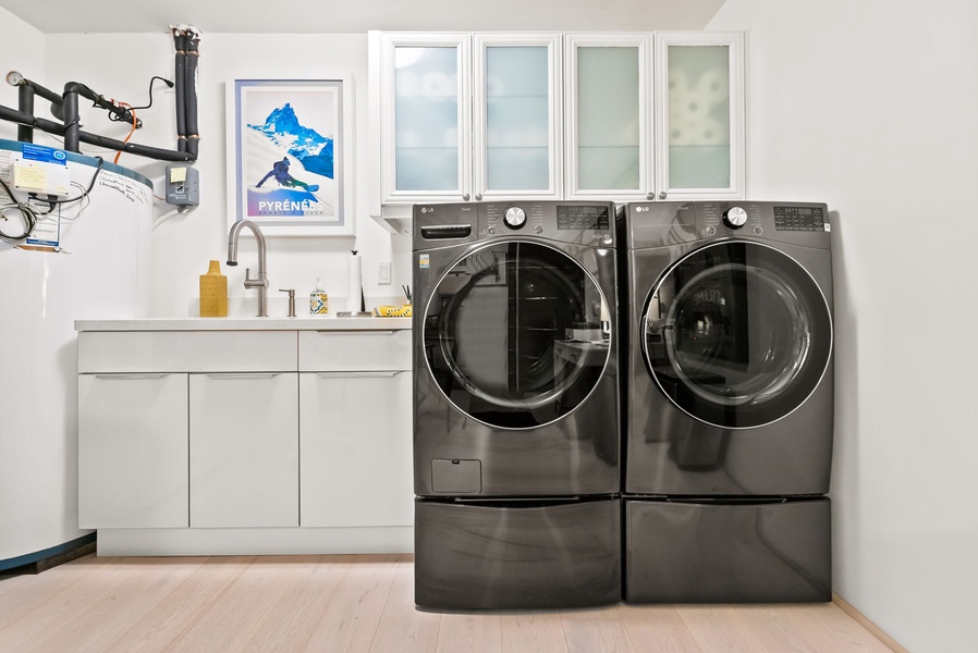 Sleek laundry room with premium washer and dryer plus custom storage cabinetry.