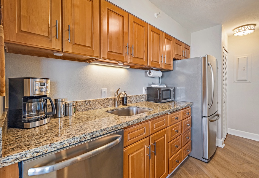 The kitchen is fully stocked with stainless steel appliances, granite countertops, and ample cabinet space for a comfortable cooking experience.