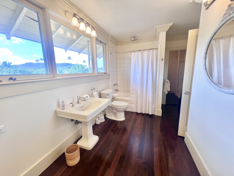 Light-filled bathroom with dual sinks, a walk-in shower, and classic design features