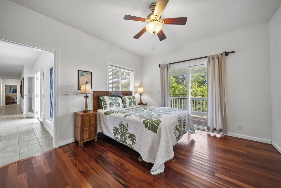 Another view of the airy guest room showcasing hardwood floors and natural light, creating a fresh and inviting retreat.