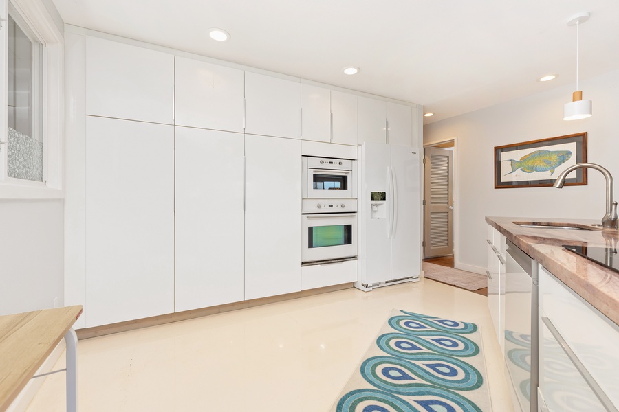 The main kitchen is fully equipped with sleek appliances and ample storage for all your culinary needs.