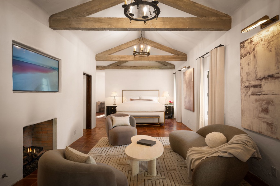 Unwind in your elegant primary suite with rustic beams meet modern luxury, complete with a cozy fireplace and peaceful bedroom sanctuary.