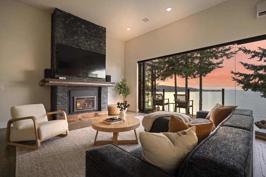 Twilight living-room ambiance showcasing the seamless connection between indoors and the bay beyond.
