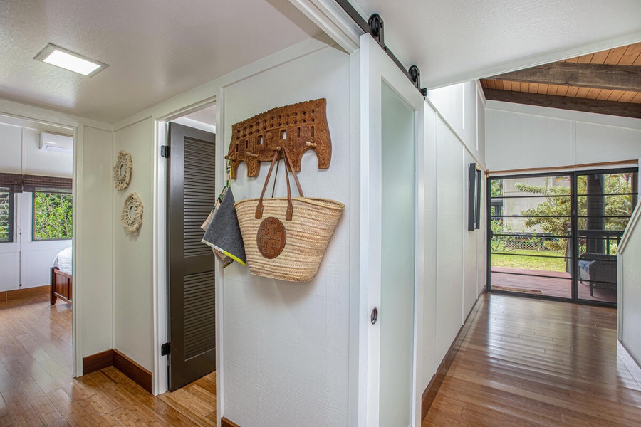 Modern barn door adds a sleek, island-chic touch to this stylish hallway space.