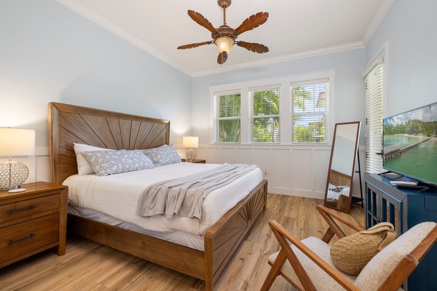 The primary suite offers a luxurious king bed, ceiling fan, and smart TV for the perfect night’s sleep.