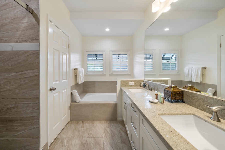 Spa-style primary bathroom with dual vanities, soaking tub, and separate walk-in shower.
