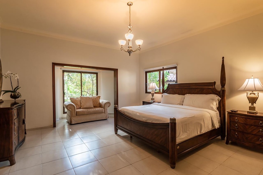 Bright guest bedroom with a comfortable bed and large windows allowing natural light.