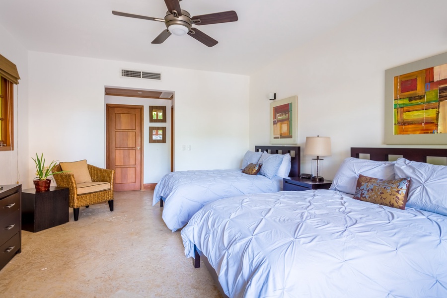 Relax in the guest bedroom featuring two cozy beds and a seating area.