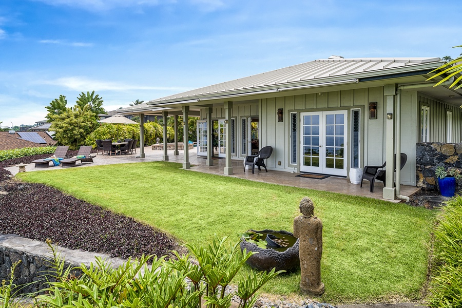 Lush tropical gardens and manicured grounds create a serene, secluded Kona atmosphere.