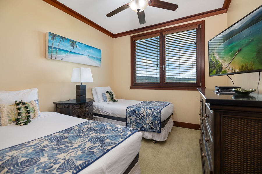 Guest bedroom with TV & two beds.