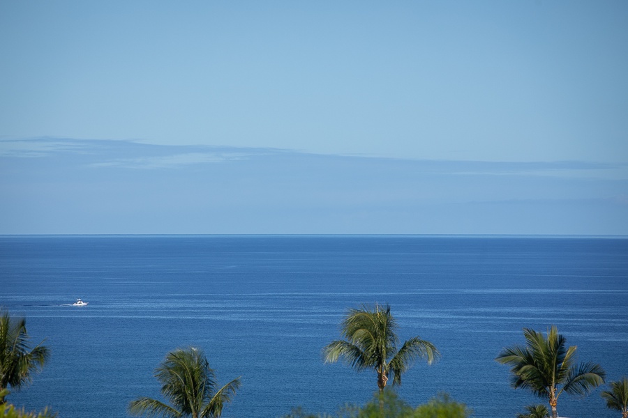 Endless blue waters and distant clouds meet at the horizon in this breathtaking ocean panorama.