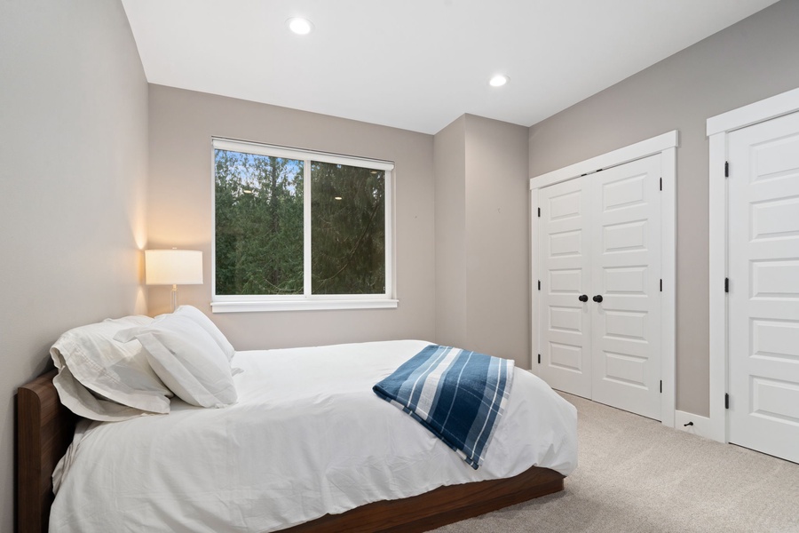 Drift off in your serene bedroom with plush white bedding, garden views, and abundant closet space for extended stays.