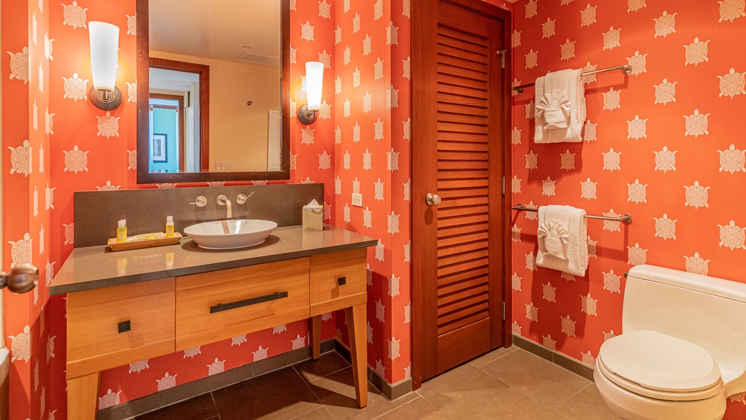 The second guest bathroom is also filled with a vibrant orange accent wall.