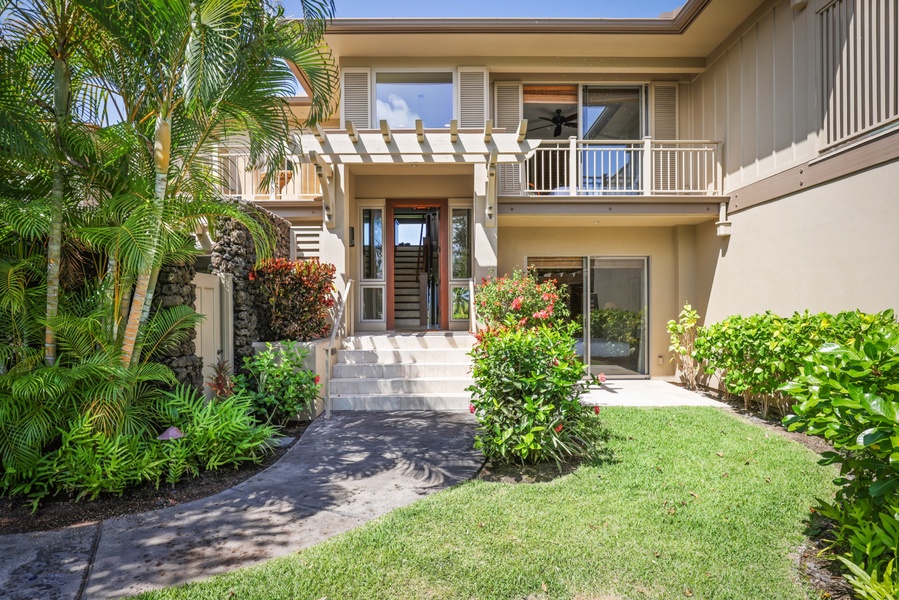 Tropical landscaping lines the front entrance of this exquisite split level villa.