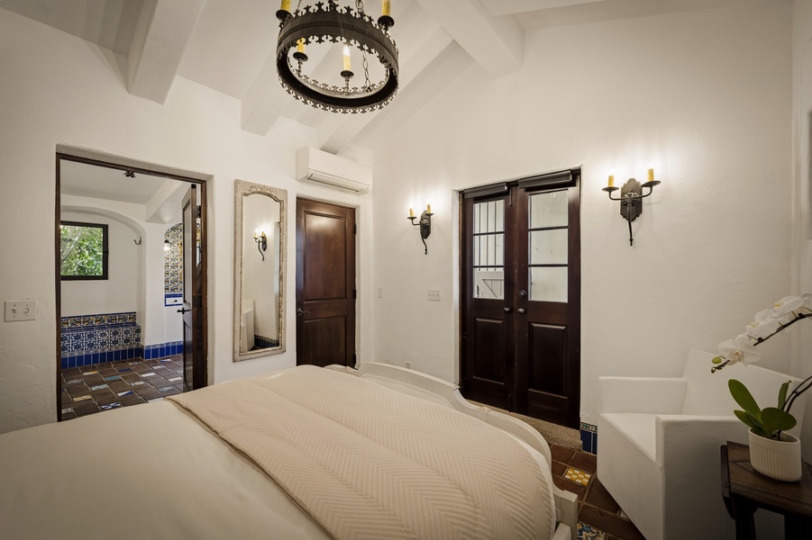 Drift off in your elegant bedroom featuring ornate chandeliers, warm sconces, and Spanish-inspired touches that create a romantic, Old-World atmosphere.