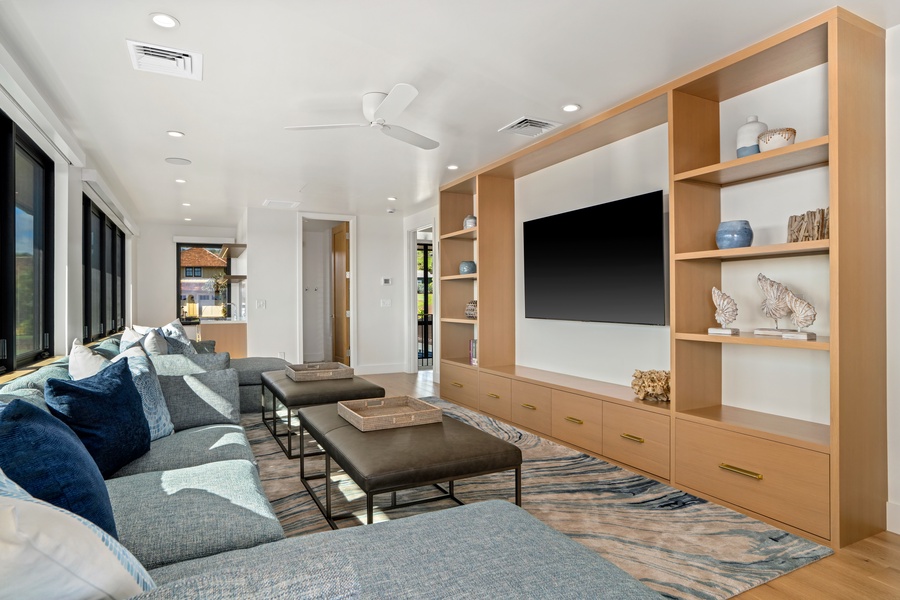 Relax on plush sectional seating while enjoying your favorite shows on the large flat-screen TV in this elegantly designed living space.