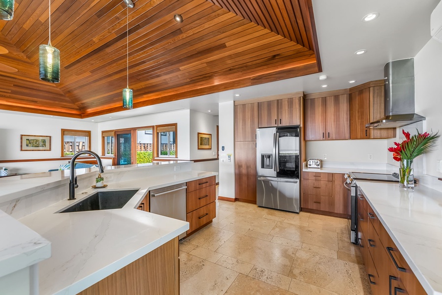Chef’s kitchen with integrated island bar and pendant lighting—perfect for breakfast or casual dining.