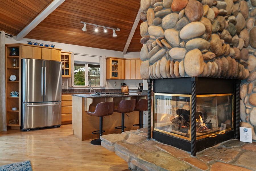 Warm up by your stunning stone fireplace while preparing meals in this beautifully appointed kitchen with vaulted ceilings and modern appliances.