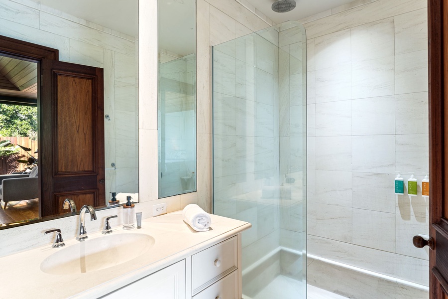 Unwind in your spa-like bathroom featuring marble finishes, a glass-enclosed shower, and luxurious amenities for complete relaxation.