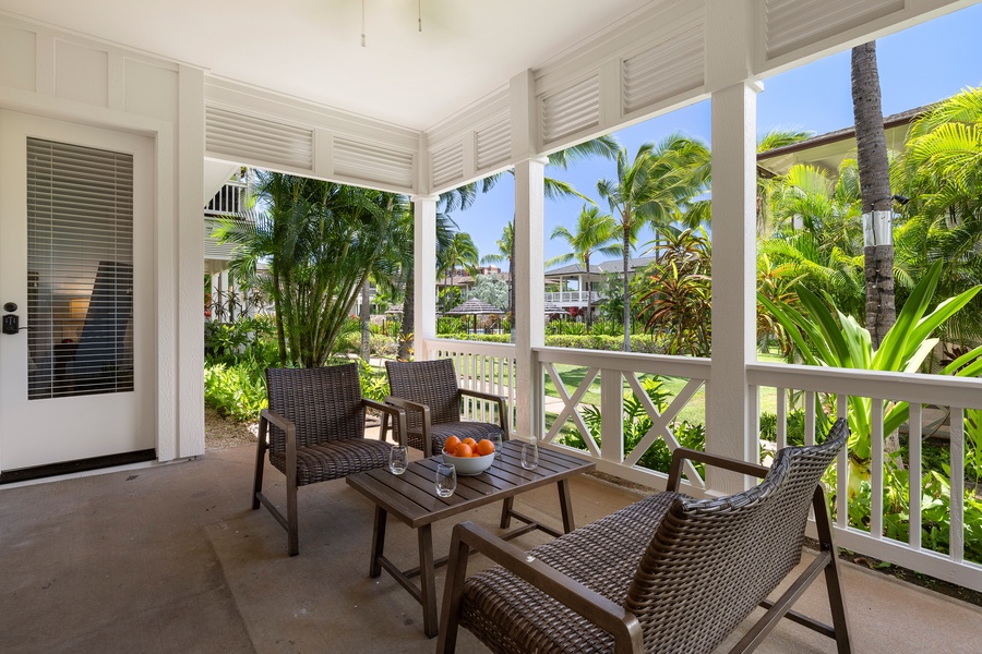 Covered lanai with deep seating and lush landscaping—your own quiet retreat at the edge of paradise.