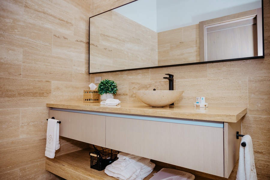 This ensuite bathroom features a large mirror and vanity.