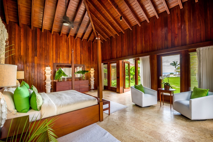 Guest bedroom with a garden view and comfortable seating area.