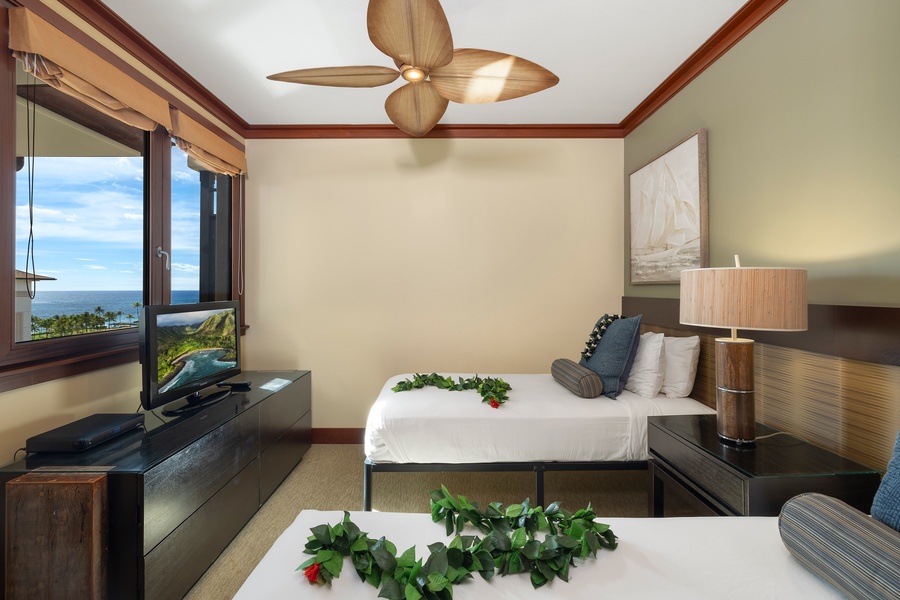 The third guest bedroom has two twin beds, a TV and a view.