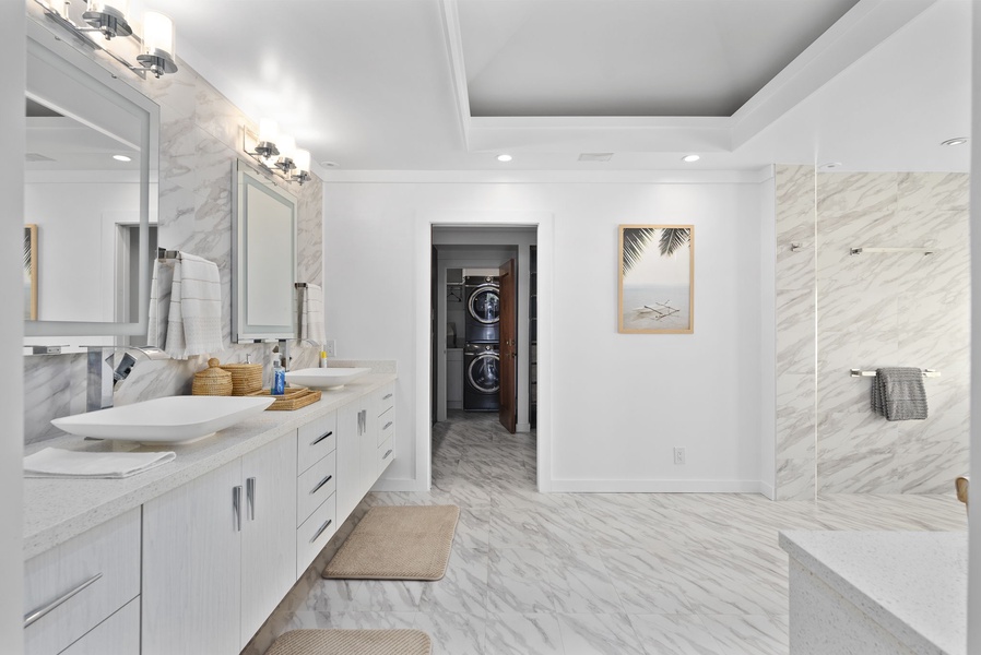 Marble bathroom with dual vanities, walk-in shower, and a bright, open layout.