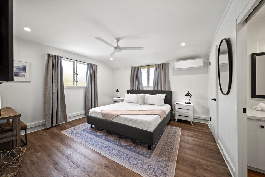Minimalist suite with a king-sized bed, serene design, and large windows for natural light and breezy comfort.