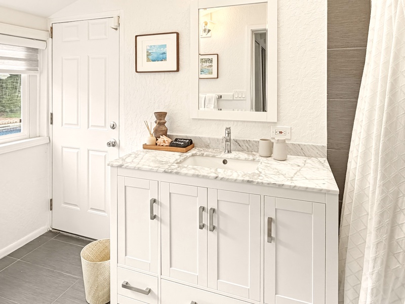Pamper yourself in this beautifully appointed bathroom with marble counters and elegant fixtures for your comfort.