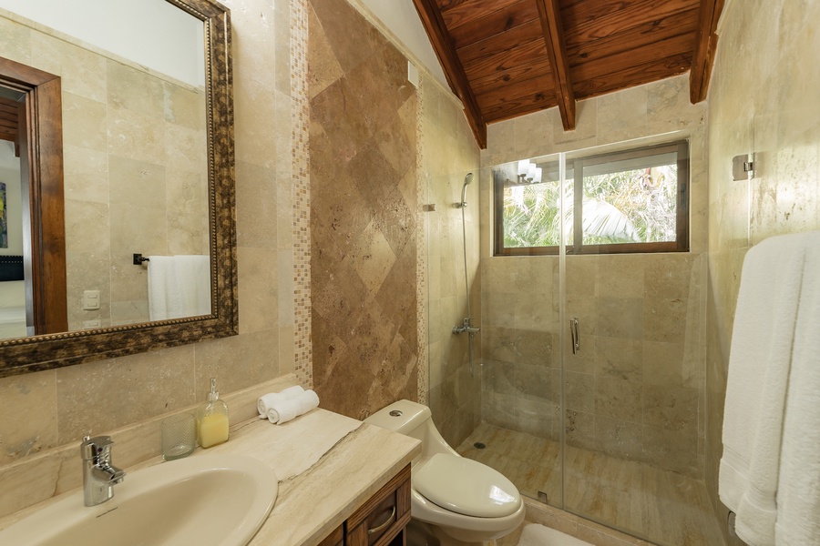 Stylish ensuite bathroom with a walk-in shower and beautiful stone details, offering a spa-like retreat.