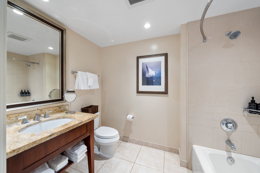 Honua Kai Konea 230/232 features a polished bathroom with warm tones and granite counters