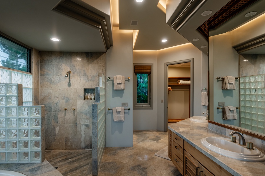 Luxurious bathroom with a spacious walk-in shower, double sinks, and ambient lighting.