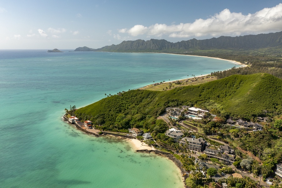A sweeping aerial view of the coastline and turquoise waters, highlighting the serene location.