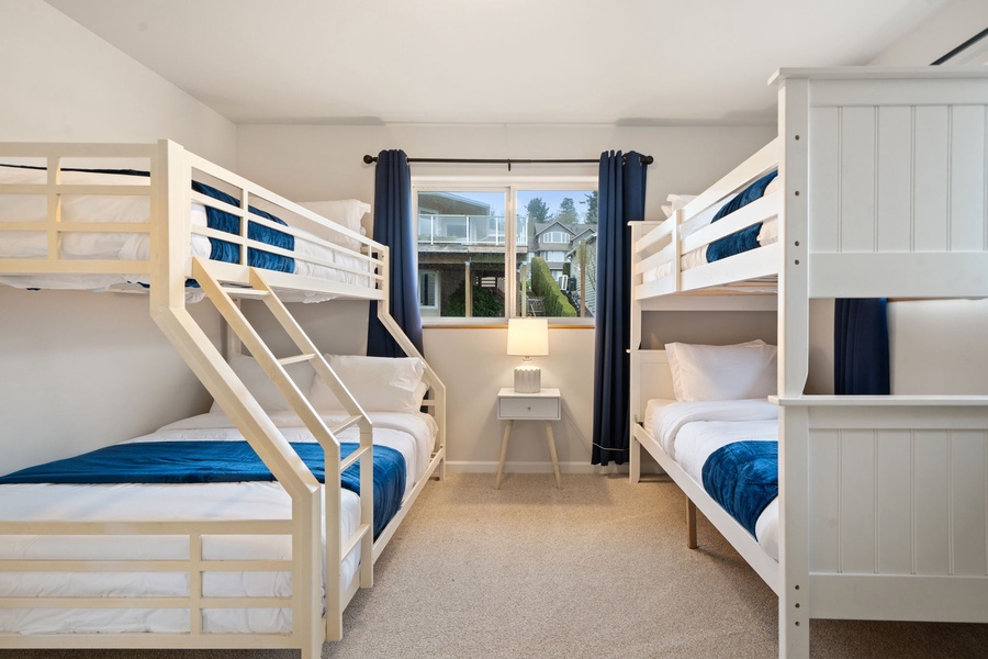 Your group's cozy bunk room with crisp white beds and navy accents creates the perfect space for restful nights together.