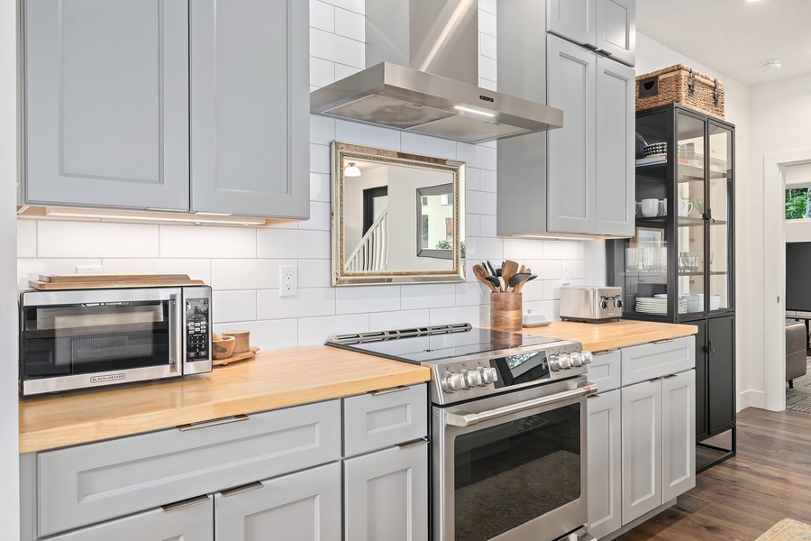 Whip up meals with ease in this fully stocked kitchen featuring an induction range and custom cabinets.