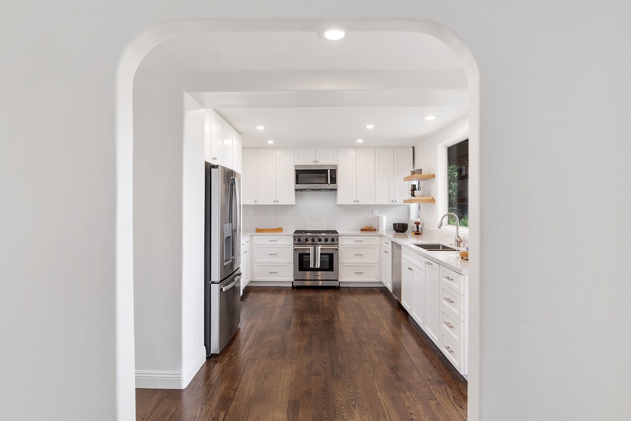 Cook up a storm in the spacious kitchen, set atop rich wooden floors with white cabinetry.