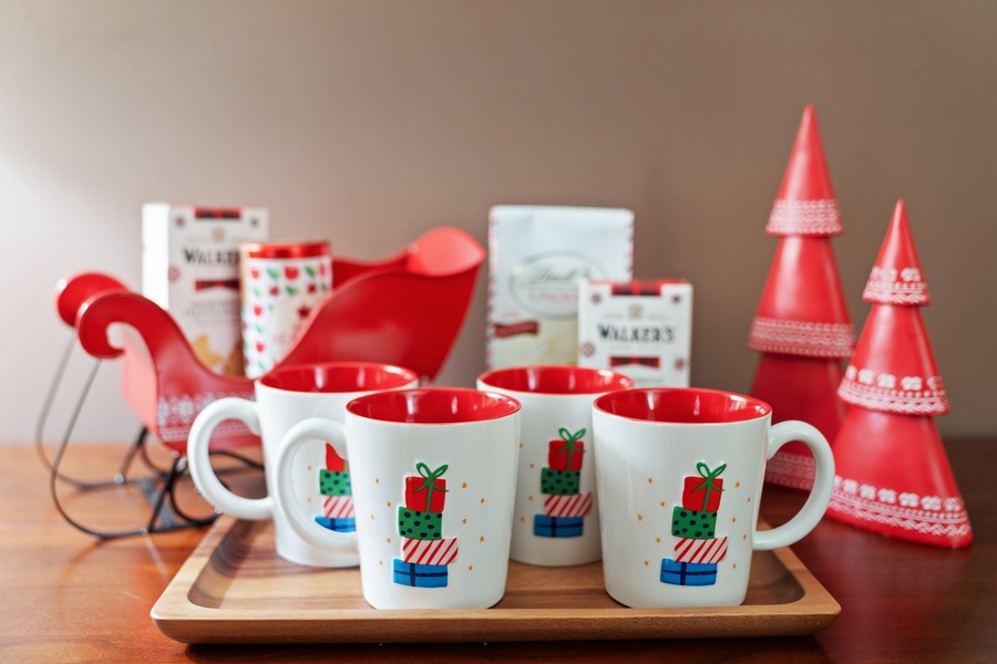 Holiday mugs and festive decorations set the mood for a cozy Christmas morning.