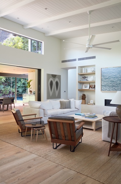 Designed for connection, the soaring great room offers comfortable seating, abundant natural light, and seamless access to the covered lanai beyond.
