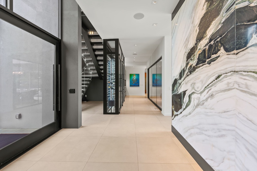 The entryway offers a warm welcome with high ceilings, organic textures, and sculptural lighting throughout.