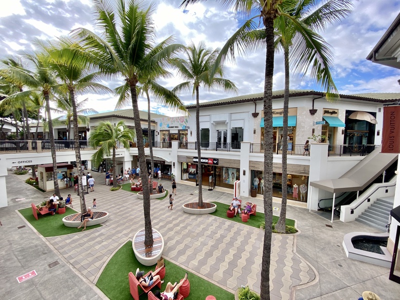 A lively outdoor shopping area with plenty of seating, perfect for a leisurely day of browsing and relaxing.