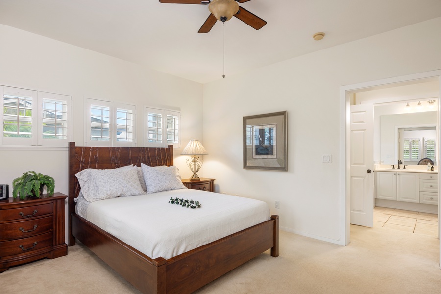 Retreat to your serene bedroom with elegant wood furnishings, soft linens, and a gentle ceiling fan creating the perfect atmosphere for restful nights.