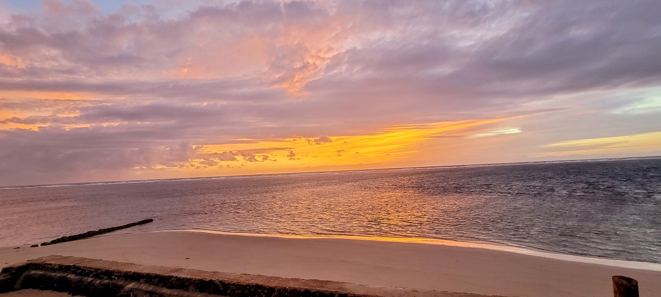 Start your day with peaceful sunrise moments on the home’s private stretch of beach, where soft morning light reflects across the calm North Shore waters.