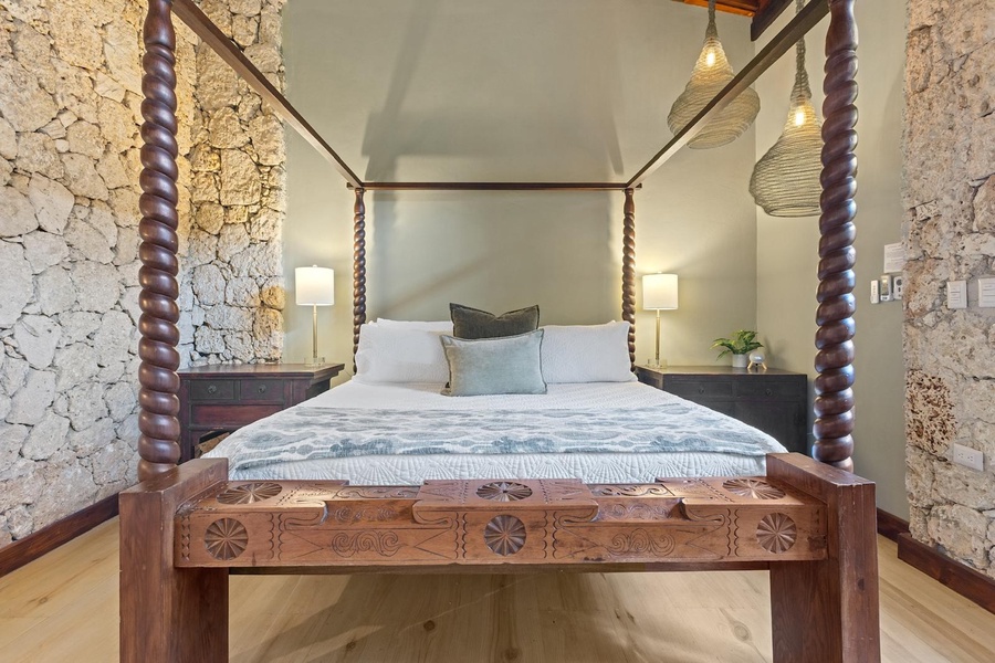 Sleep comfortably in this charming four-poster bed with intricately carved wooden details.