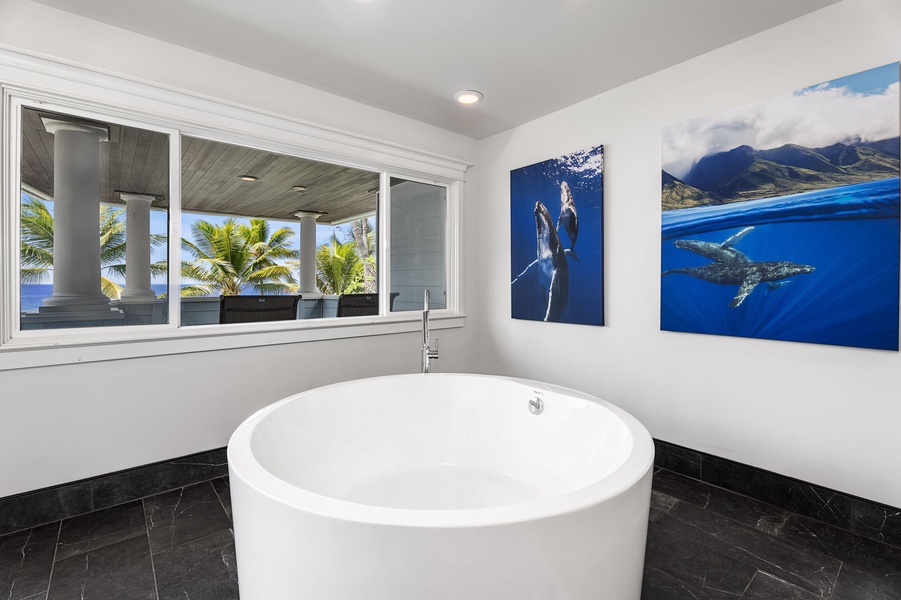 The large soaking tub offers a peaceful retreat with tropical artwork and views.